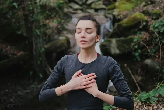Person practicing breathing exercises outdoors